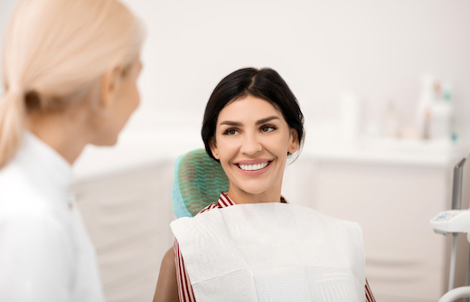 Beautiful woman smiling sitting in front of her dentist being happy about her future teeth whitening